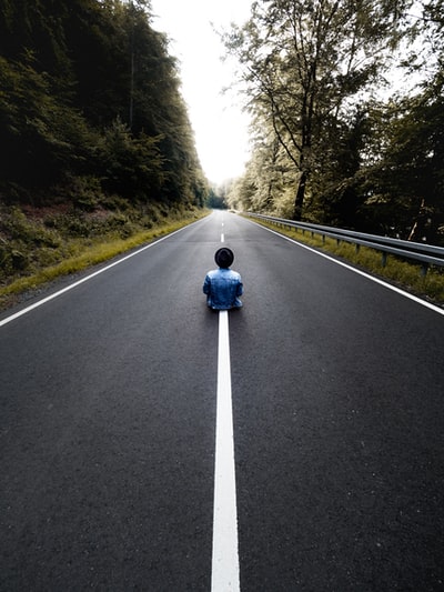 穿蓝色夹克的人白天骑摩托车上路